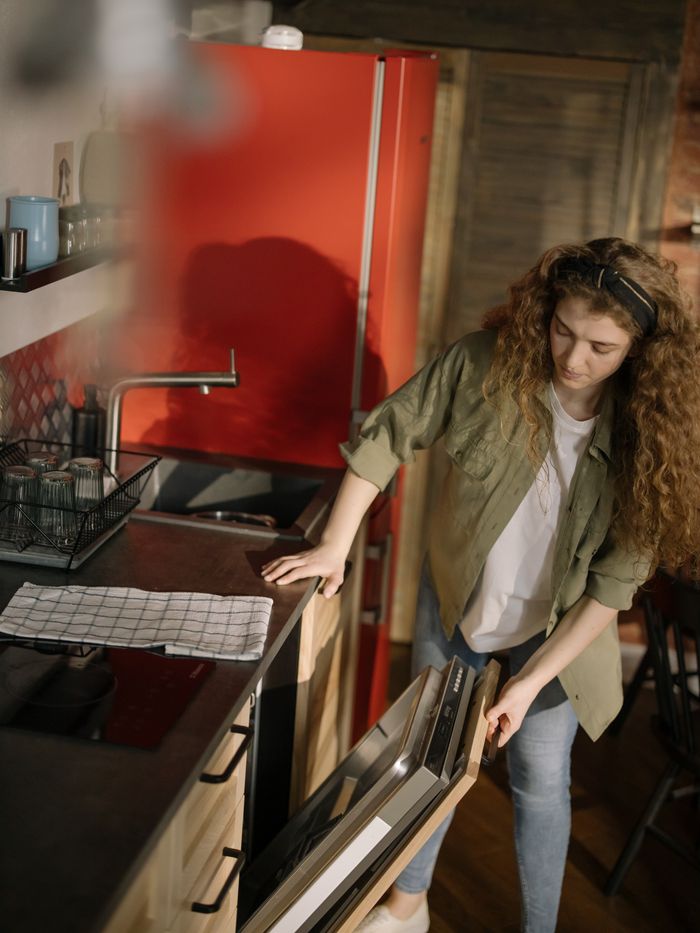 portfolio-08 Caucasian woman cleans a modern kitchen, showcasing cleanliness and efficient kitchen appliances.